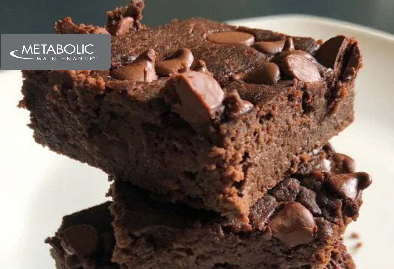 Close up of a chocolate brownie with chips and a Metabolic Maintenance logo overlay