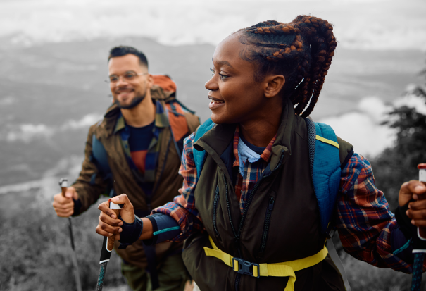 Two hikers with backpacks trekking along a scenic mountain trail during a nature walk