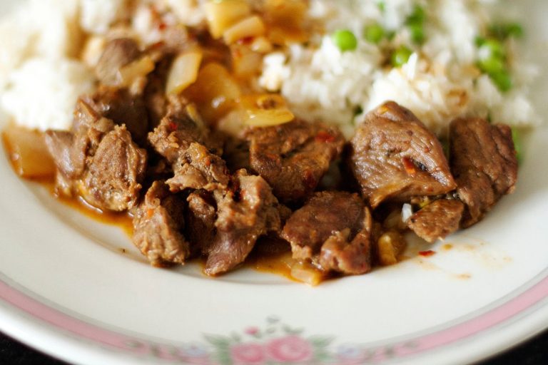 Plate of tender beef chunks with sauce served over rice