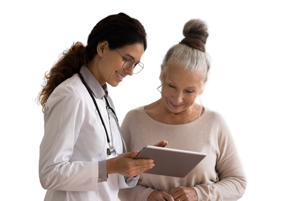 A doctor and an older woman smile as they look together at a tablet during a consultation